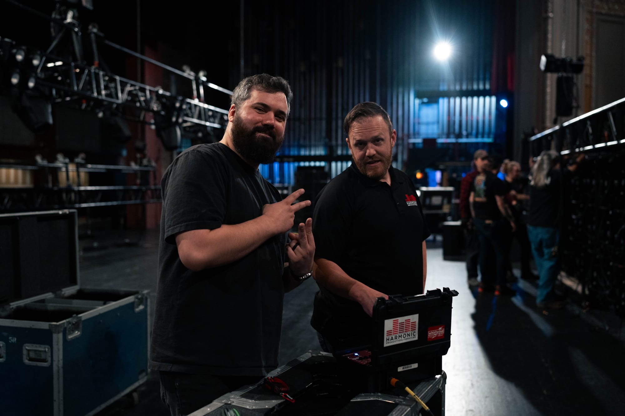 Two crew members posing backstage with production case