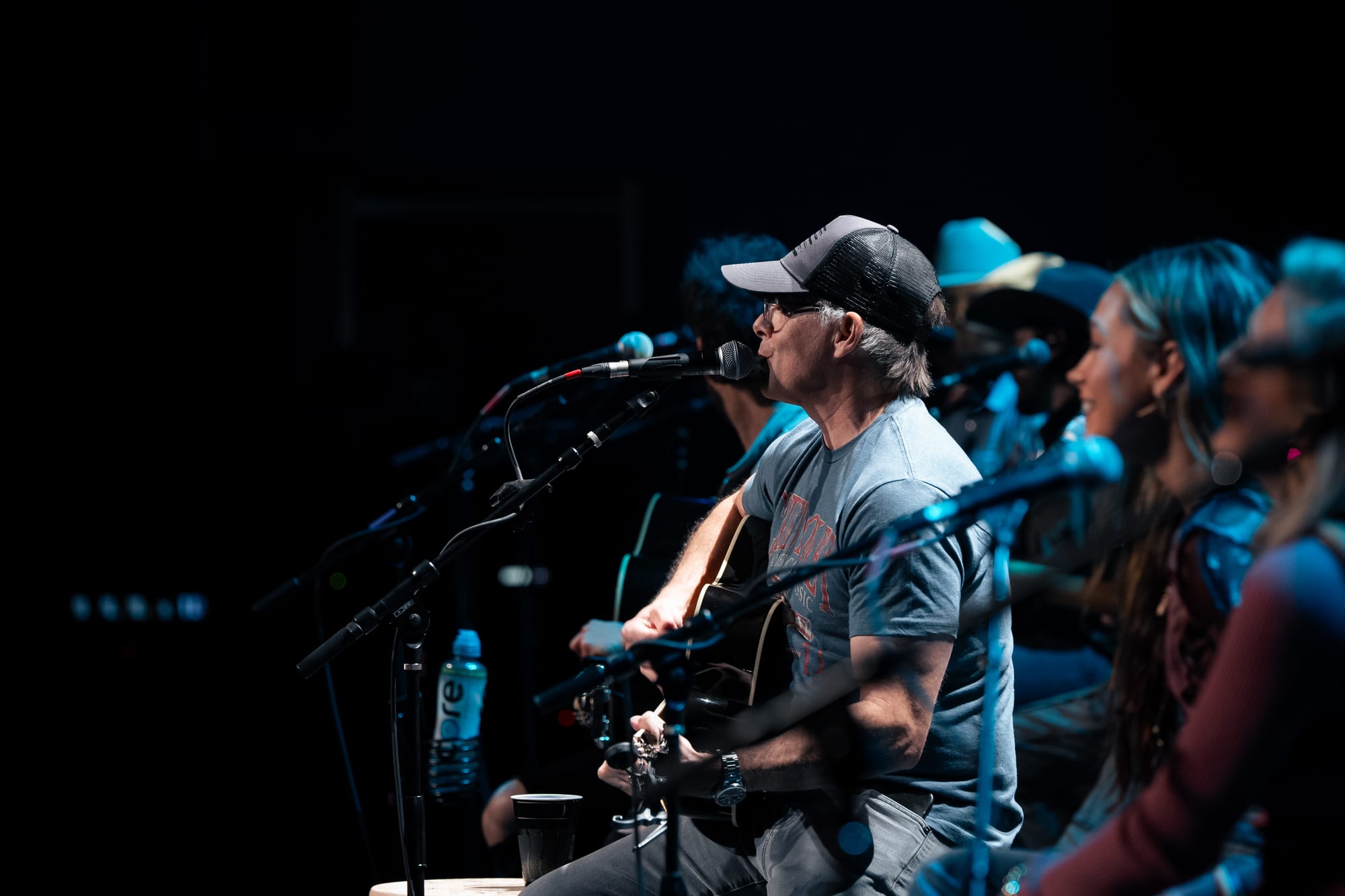 Musician singing into a microphone on stage