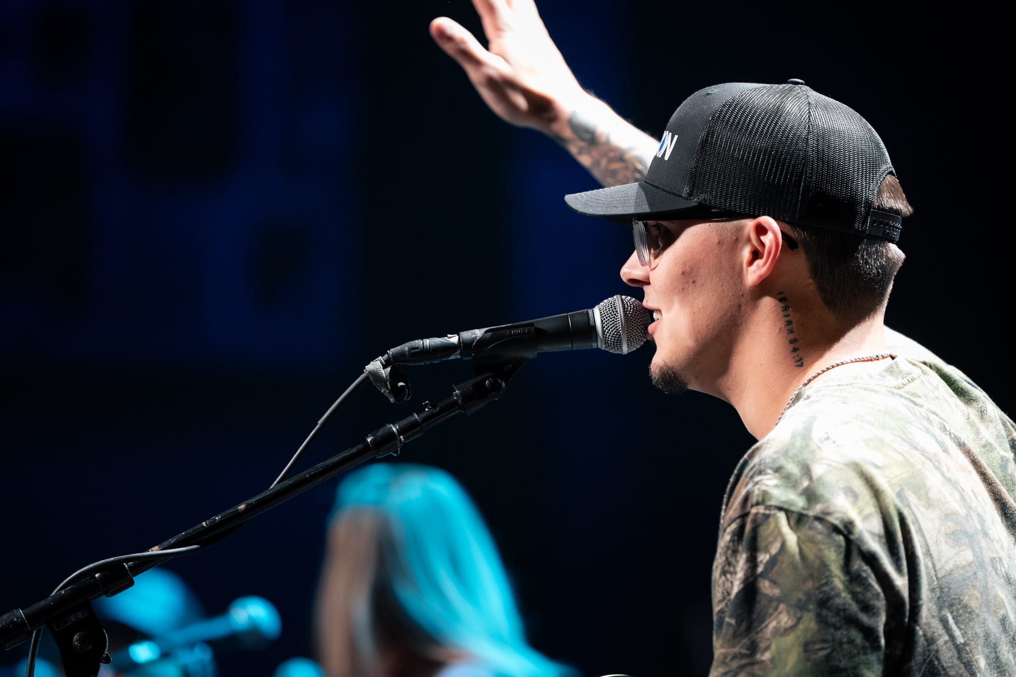 Close-up of a performer singing with arm raised