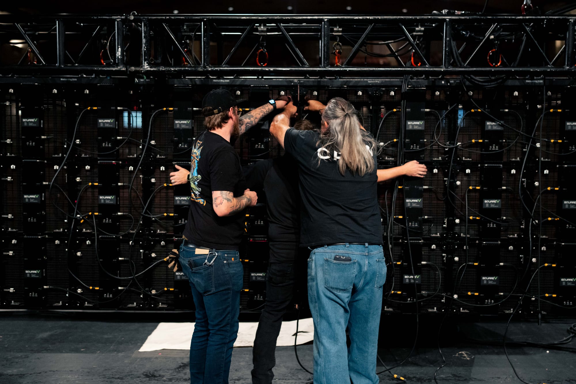 Crew assembling an LED video wall backstage