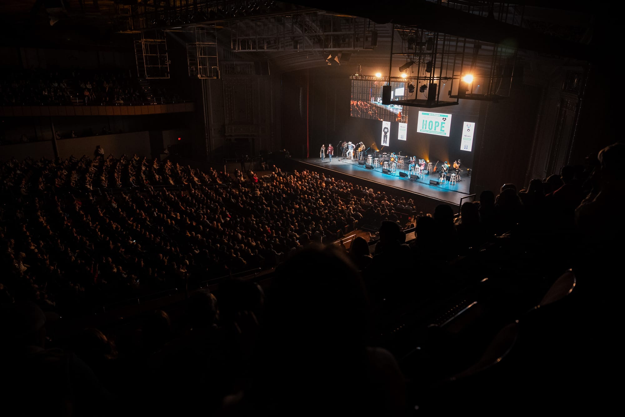 Wide shot of the full stage and audience during the benefit
