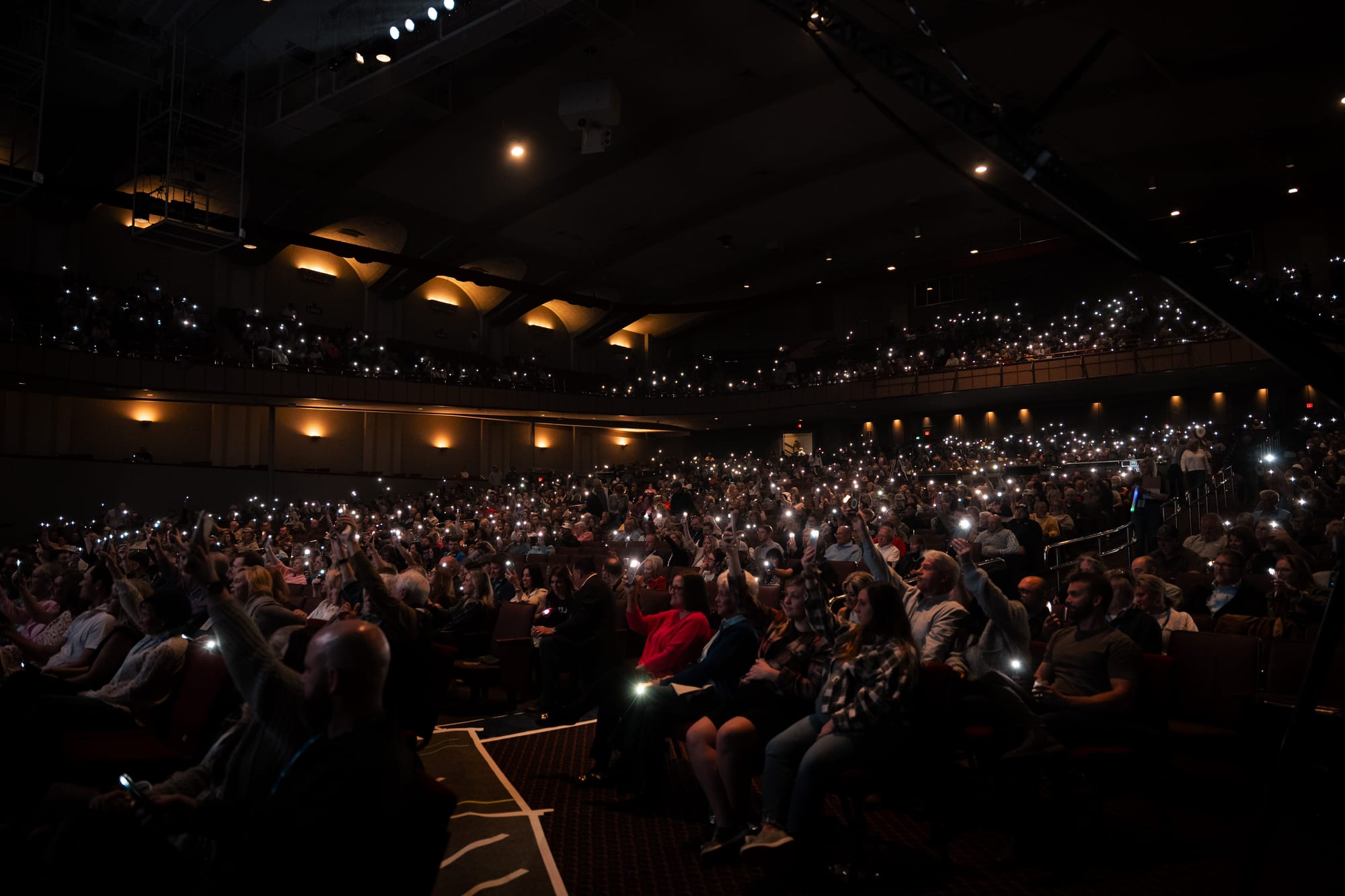 Audience holding up phone lights during the show