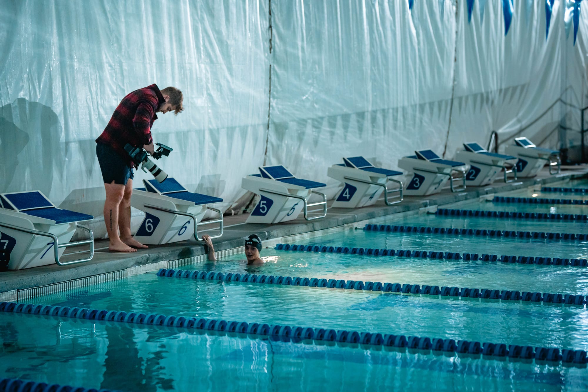 Crew reviewing footage on a gimbal rig poolside