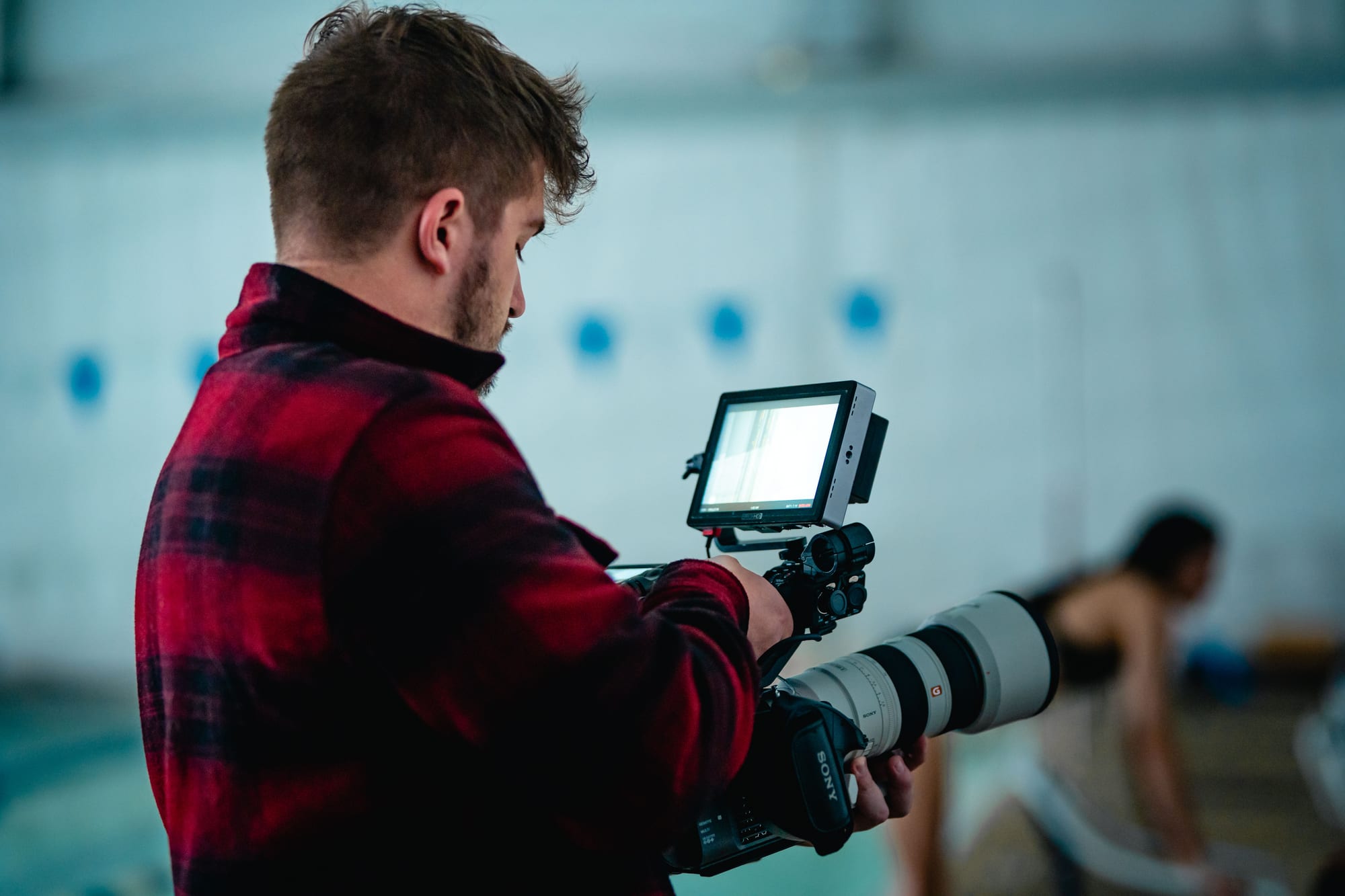 Photographer holding a long lens camera with monitor