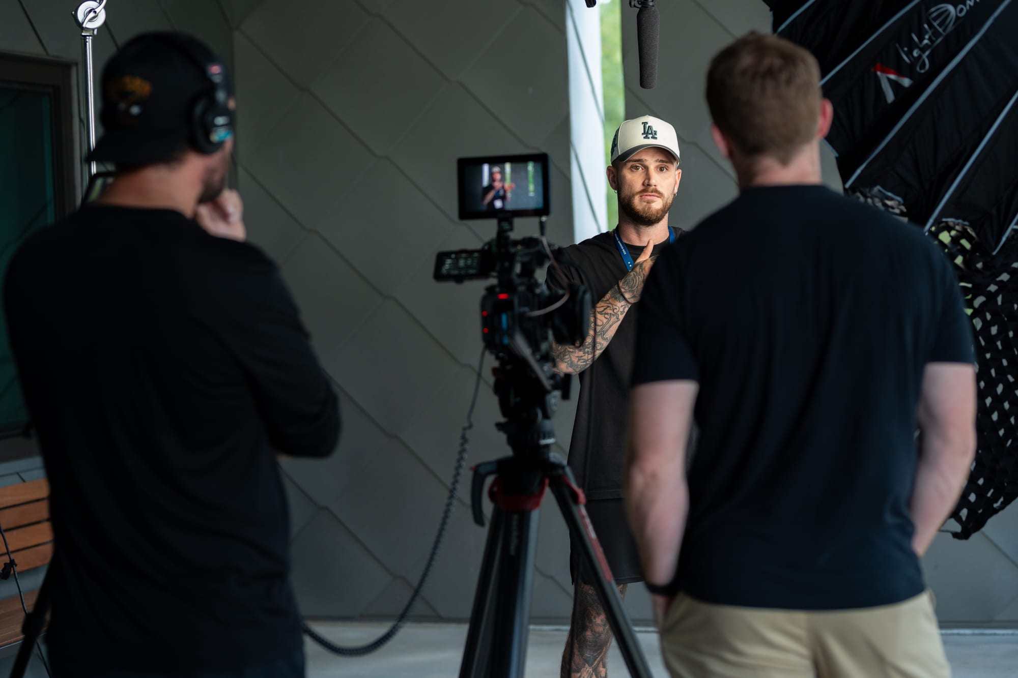 Crew filming subject against a modern building
