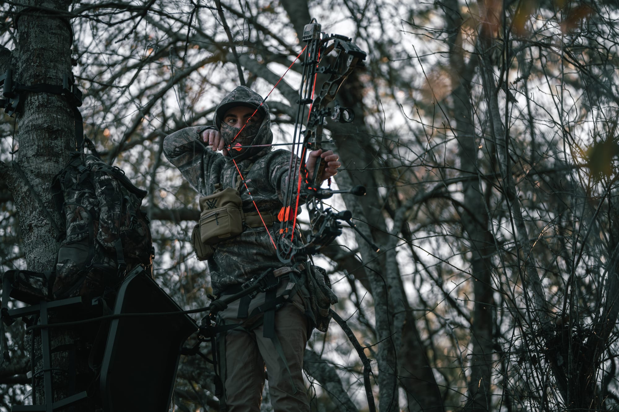 Bowhunter at full draw in the woods