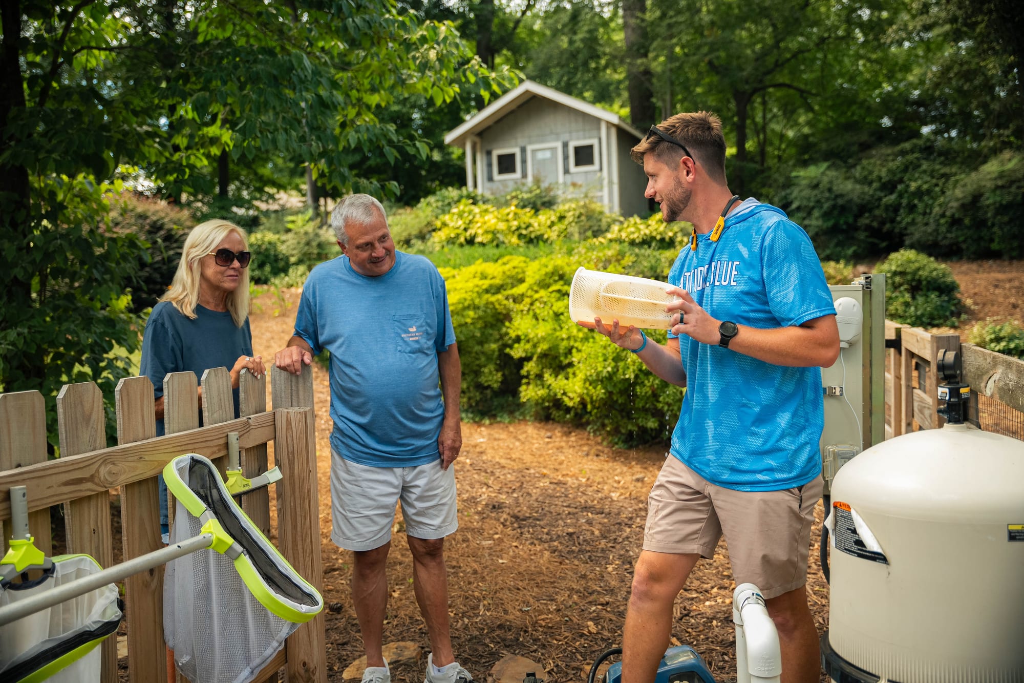 Pool technician talking with homeowners