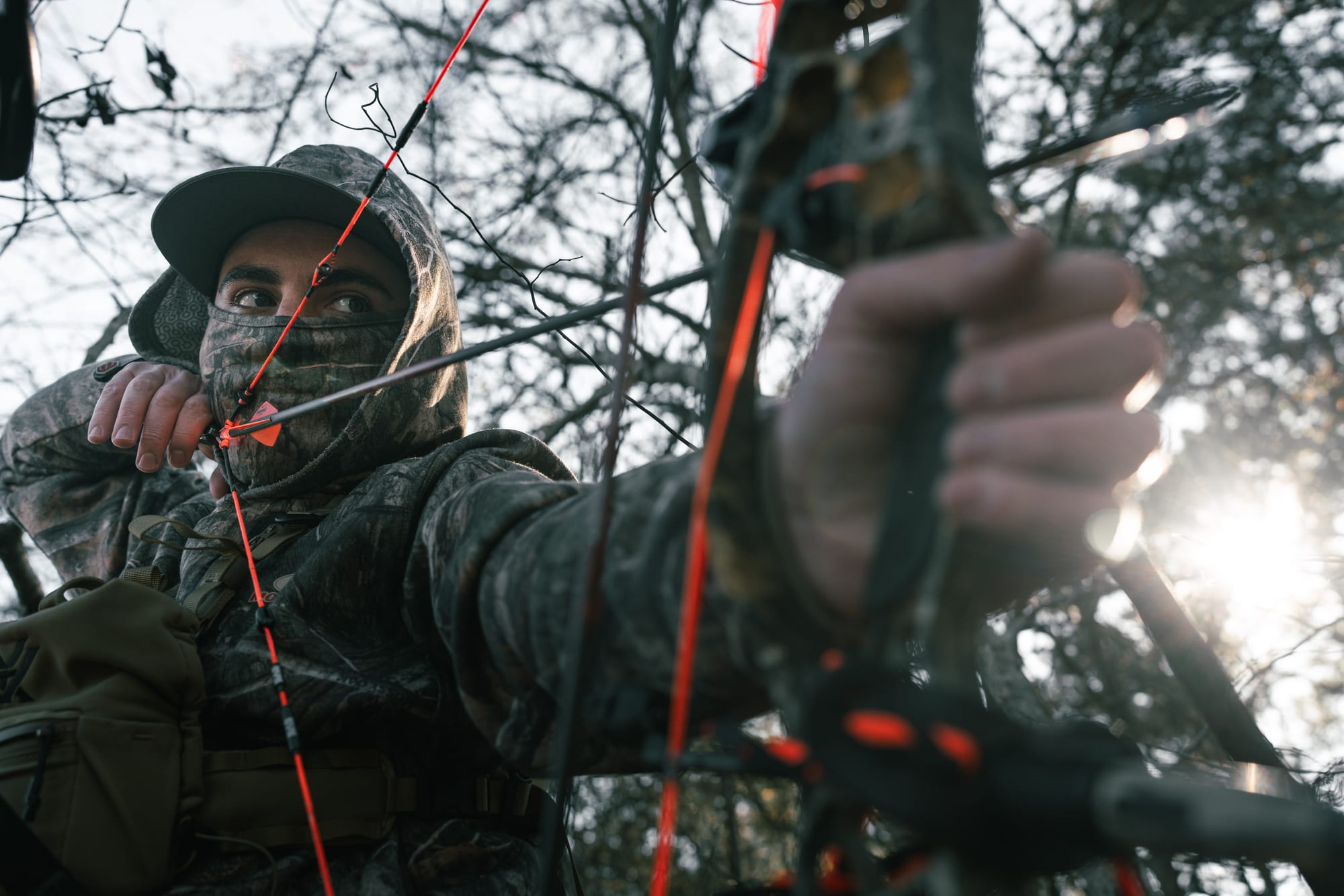 Bowhunter drawing bow close up