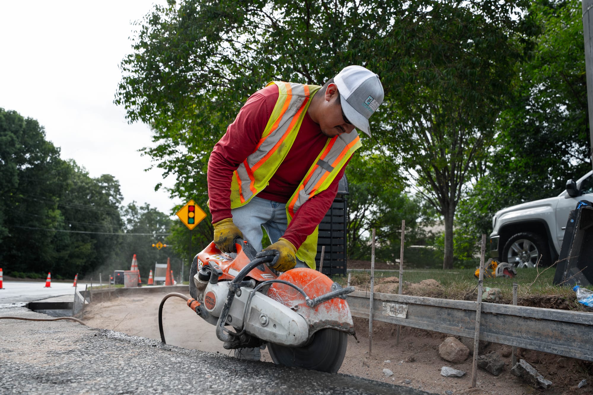 Worker cutting concrete with saw