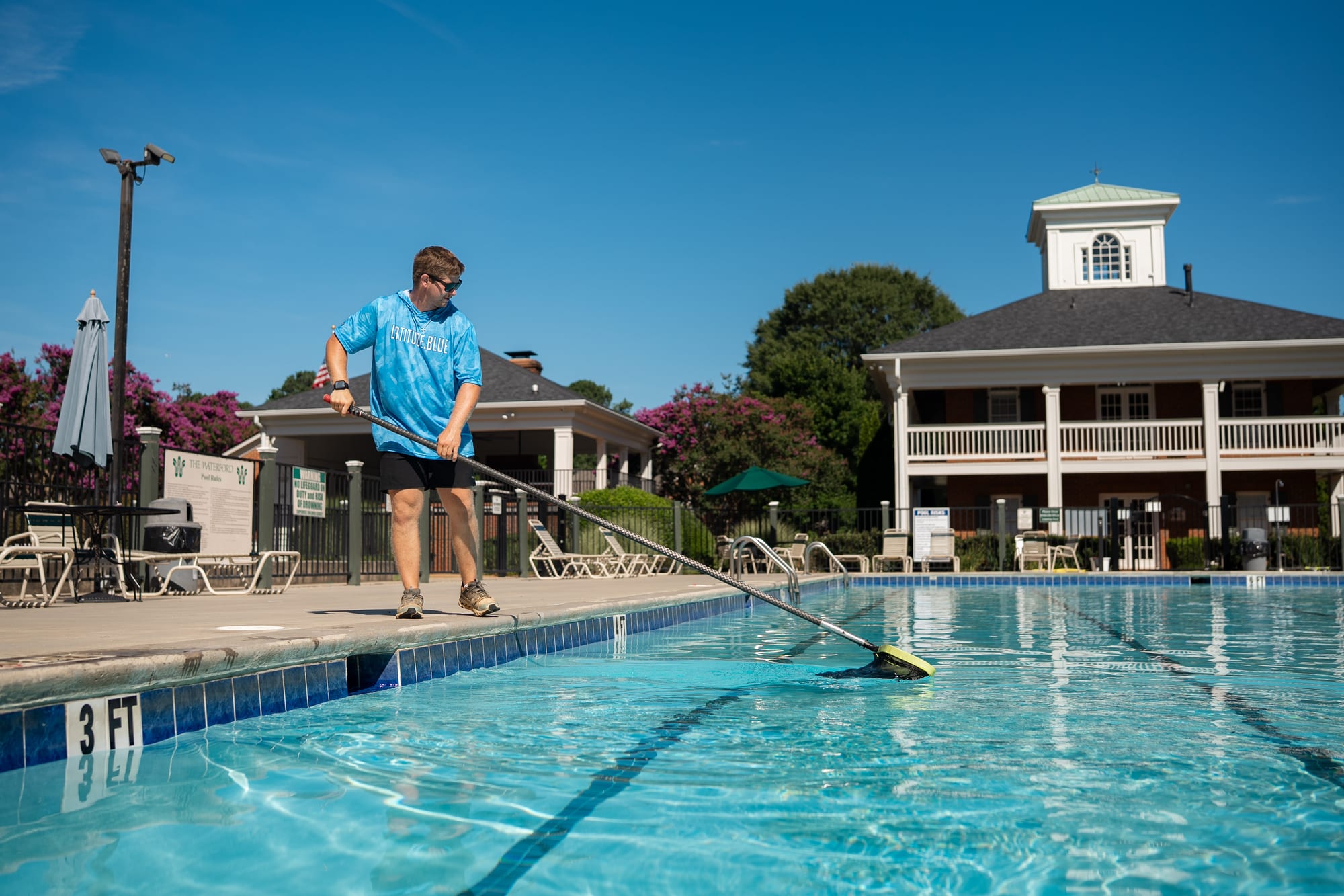Pool technician skimming a pool